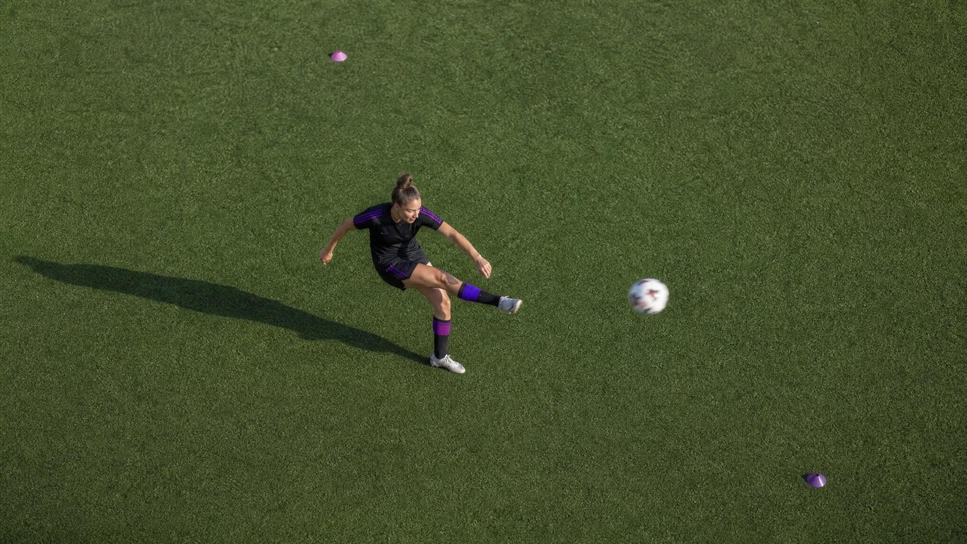 Bird's-eye view of Sarah Brasero kicking a soccer ball during training.