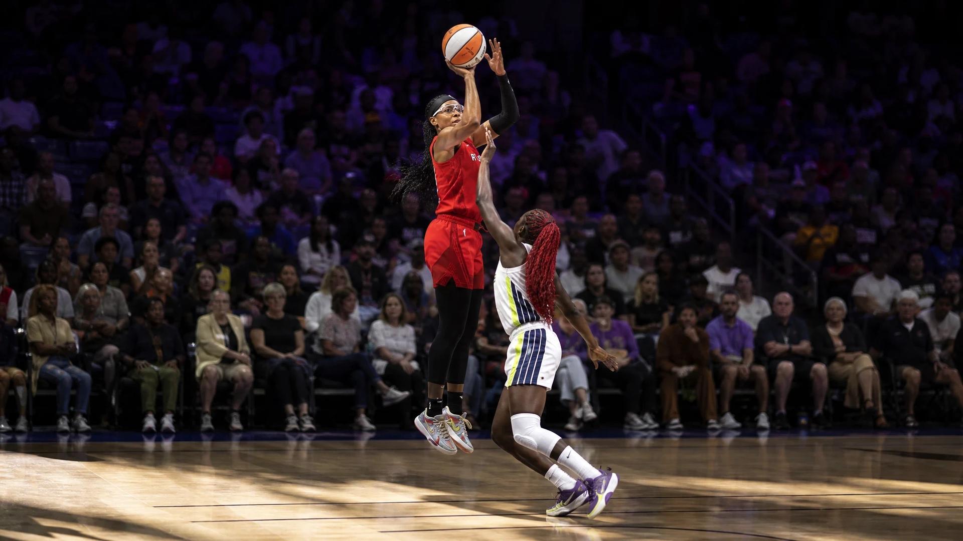 Allisha Gray mid-air taking a jump shot during a basketball game.
