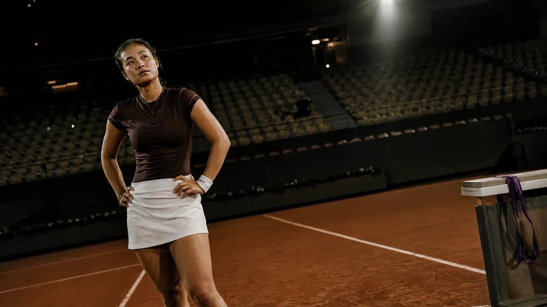 A reflective moment featuring tennis player Alex Eala on the court after her match.