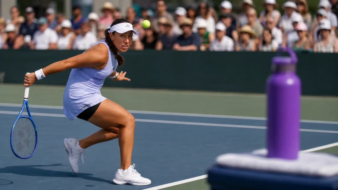 Jessica Pegula focused on the game in a tennis match, with a violet hydration bottle visible in the corner.