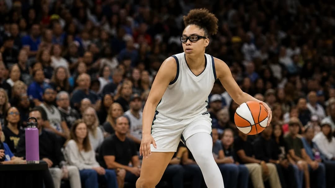 Olivia Miles dribbles the basketball against a backdrop of cheering fans in the arena.
