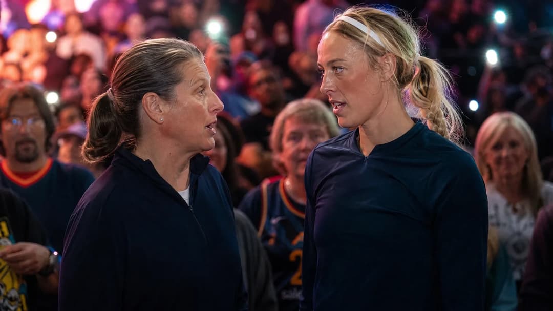 Sophie Cunningham and Cheryl Reeve engage in a serious conversation surrounded by an enthusiastic crowd.