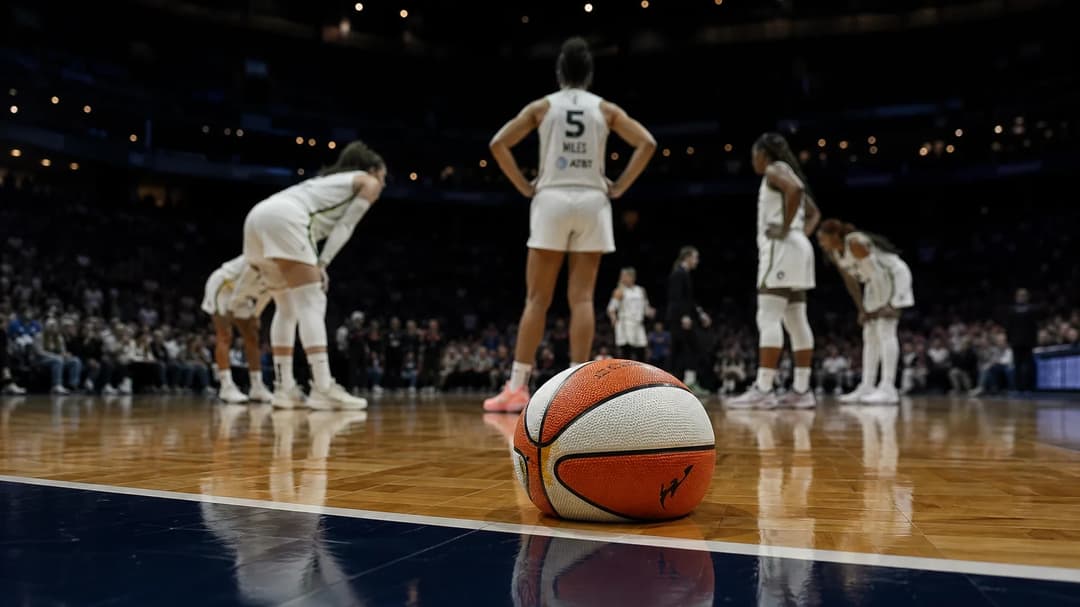 A deflated basketball on the court with Lynx players in the background.