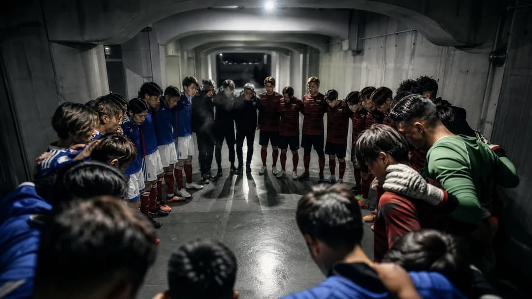 Players huddle together in a stadium tunnel, preparing for a match.