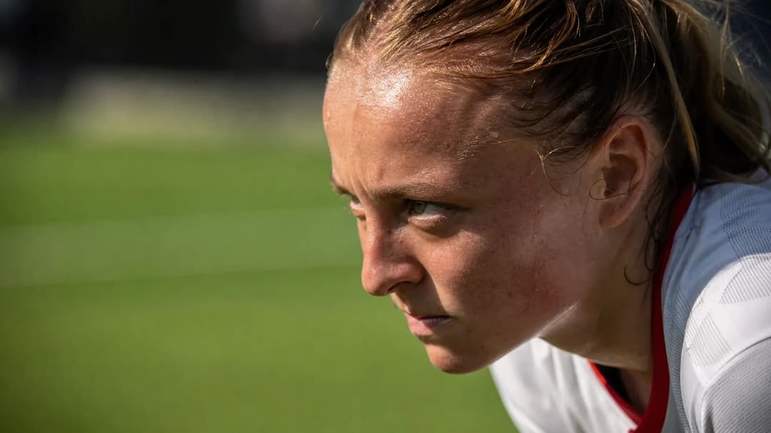 Close-up of a female football player preparing for a free kick.