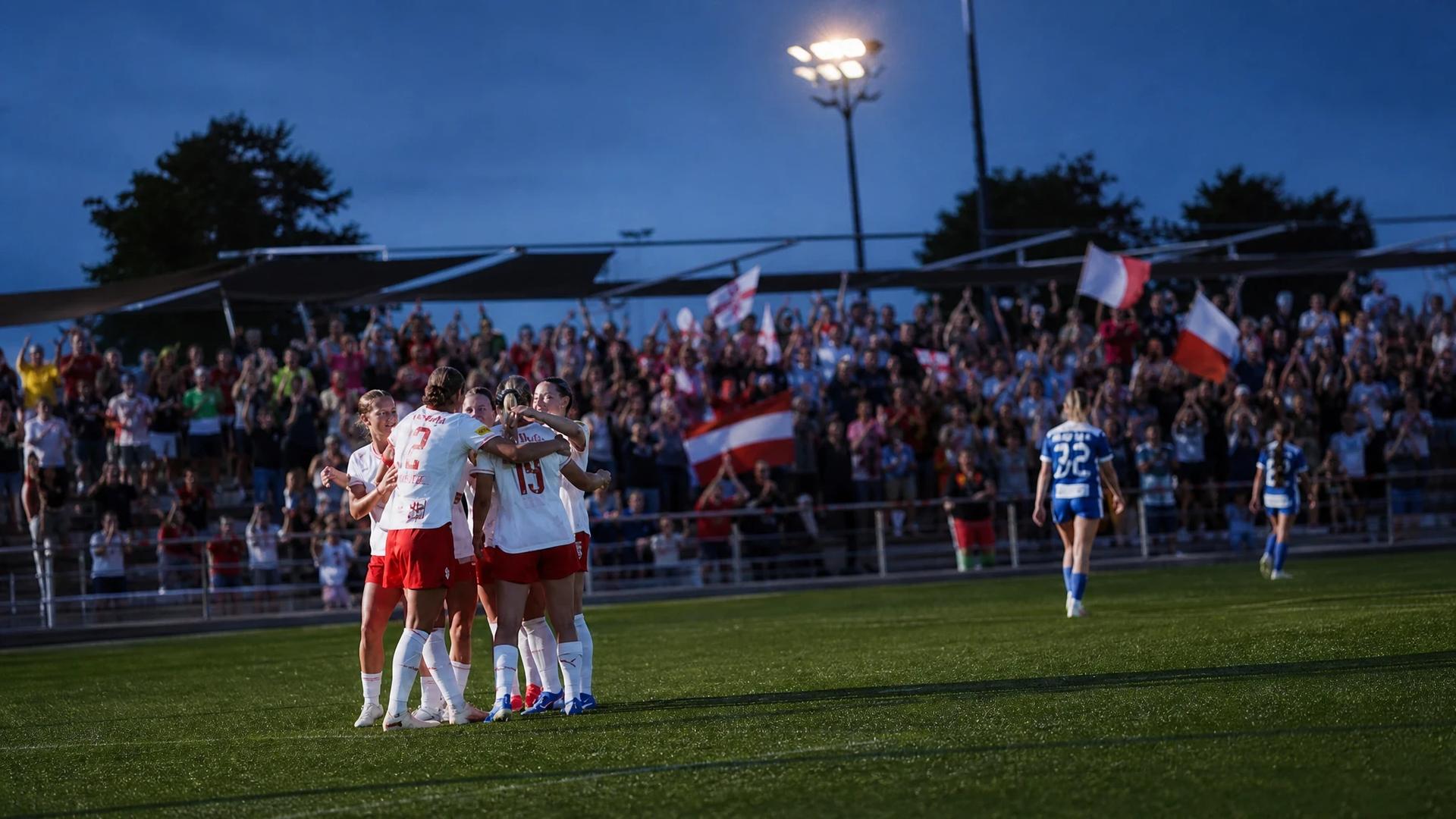 Celebration of players from FC Red Bull Salzburg Frauen during a twilight football match.