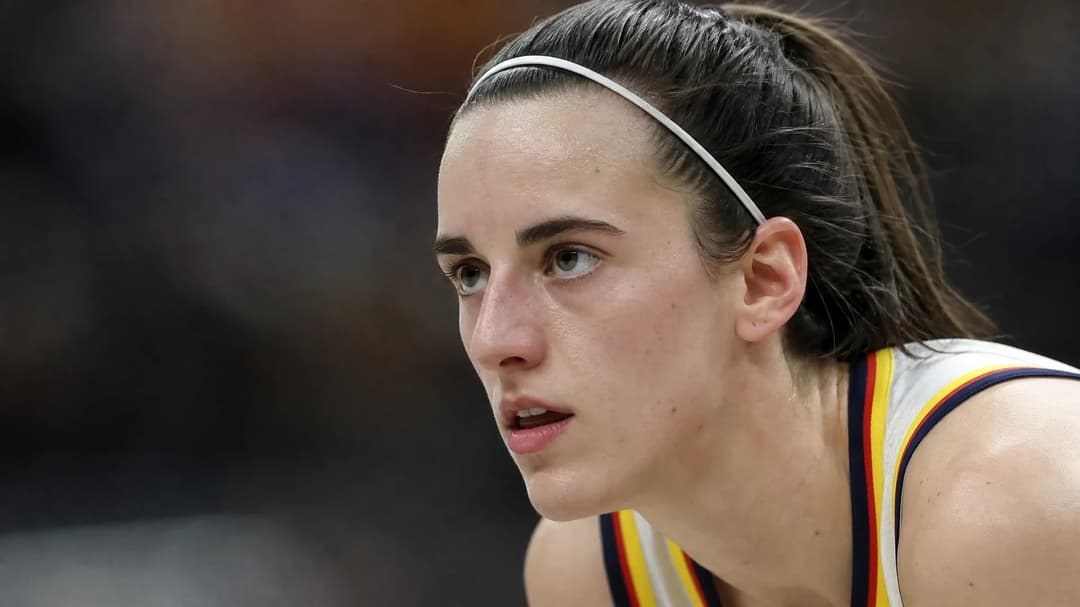 Close-up of Caitlin Clark in a basketball jersey, showing concentration on the court.
