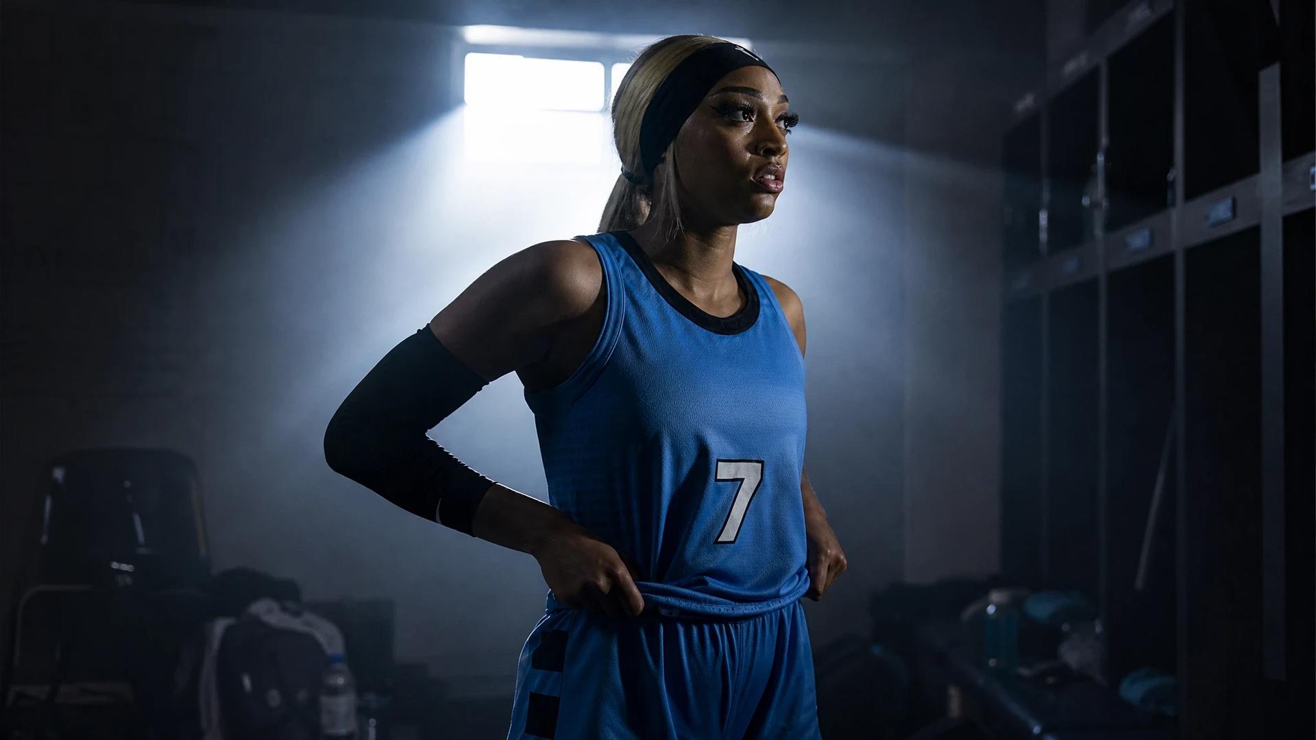 DiJonai Carrington adjusting her uniform in a lit locker room.