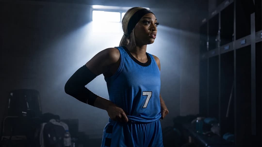 DiJonai Carrington adjusting her uniform in a lit locker room.