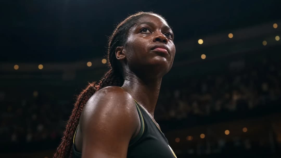 A low-angle shot of Dominique Malonga celebrating her victory after a basketball game, shadows highlighting the intensity of the moment.