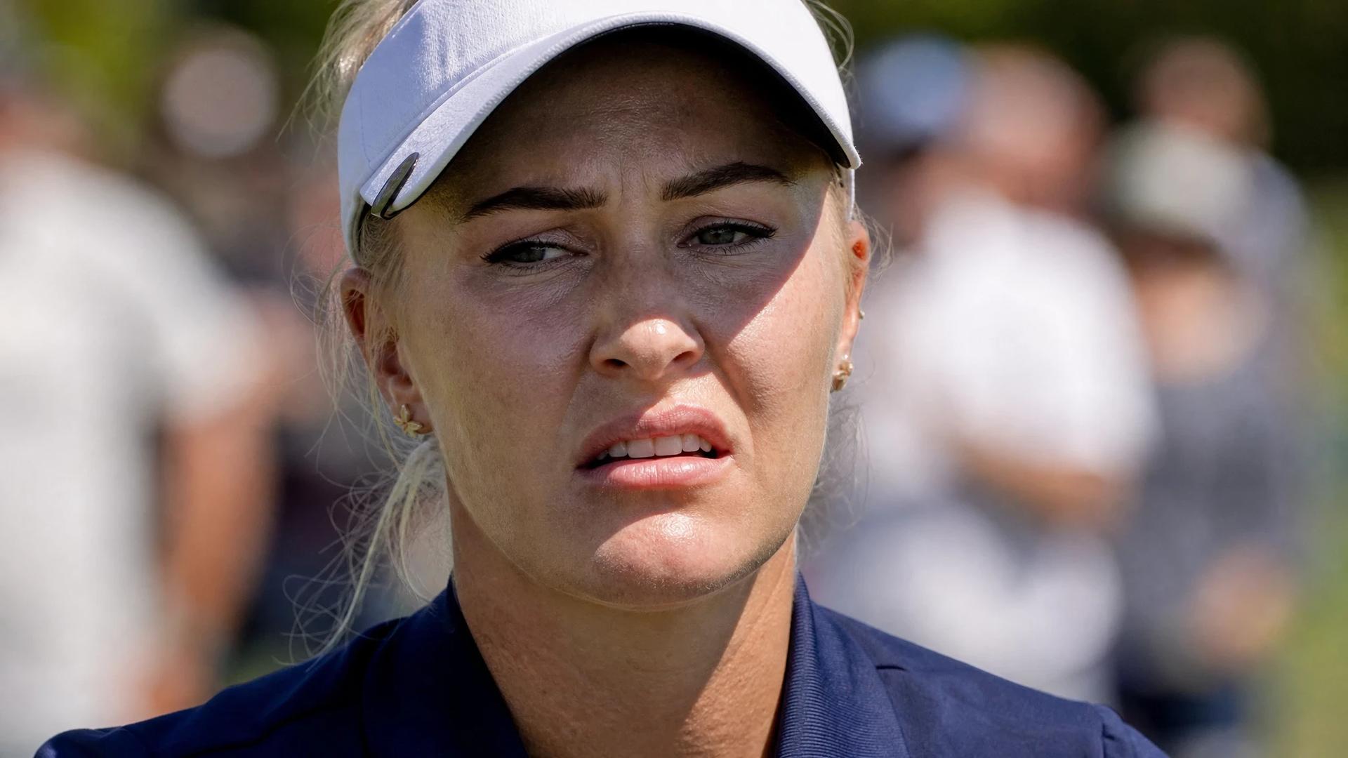 Close-up of a female golfer displaying a tense expression during a match.