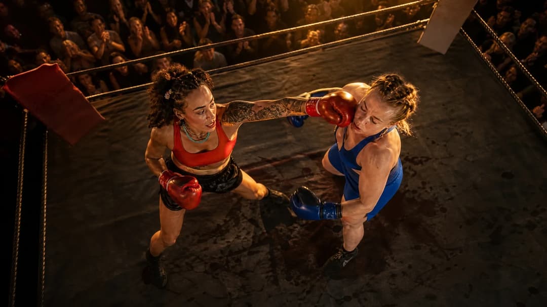 A bird's-eye view of two female boxers in a ring during a match.