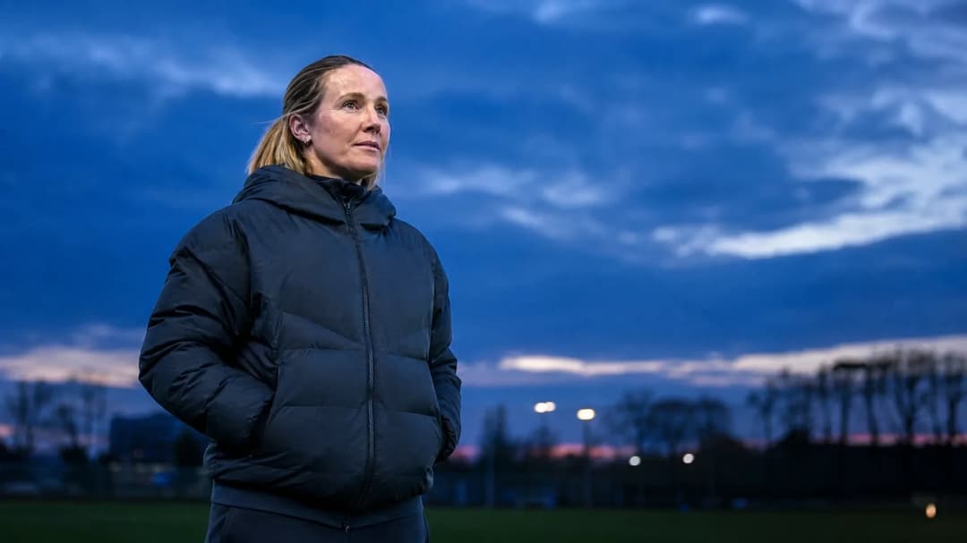 Chelsea head coach Sonia Bompastor in a thoughtful moment during dusk at the training ground.