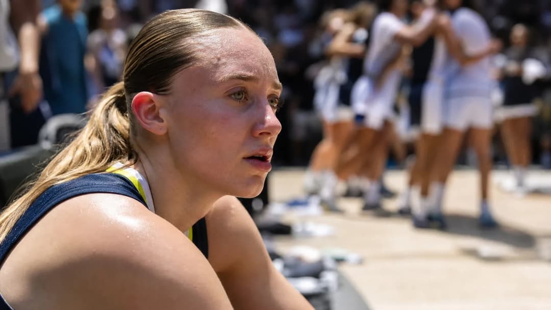 Close-up portrait of basketball player Paige Bueckers sitting on a bench post-match.