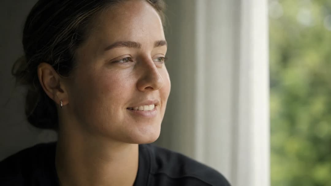 Ella McBride, a young Canadian defender, is captured in a reflective moment near a window.