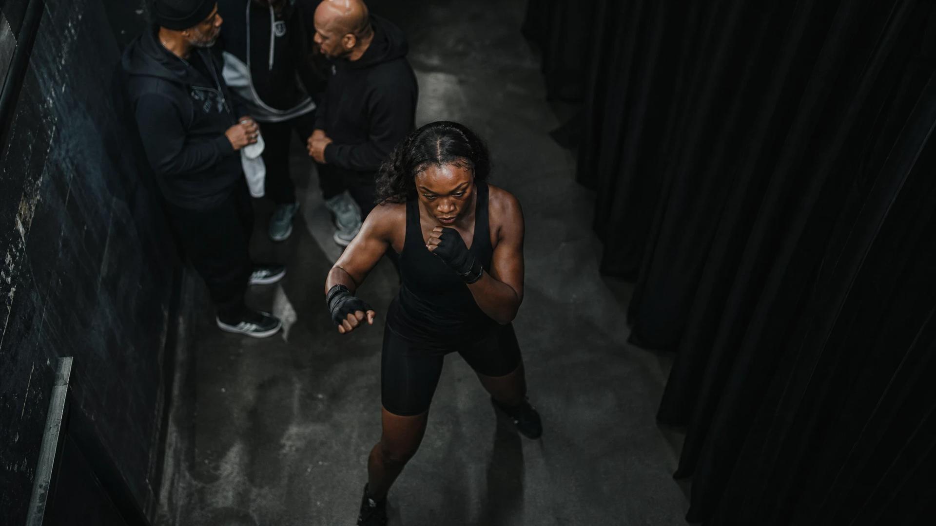 Claressa Shields warming up in a dimly lit backstage area before her title fight.