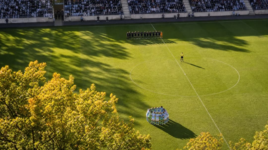 Bird's-eye view of a football match between Uppsala and Malmö, with players huddled on the pitch.