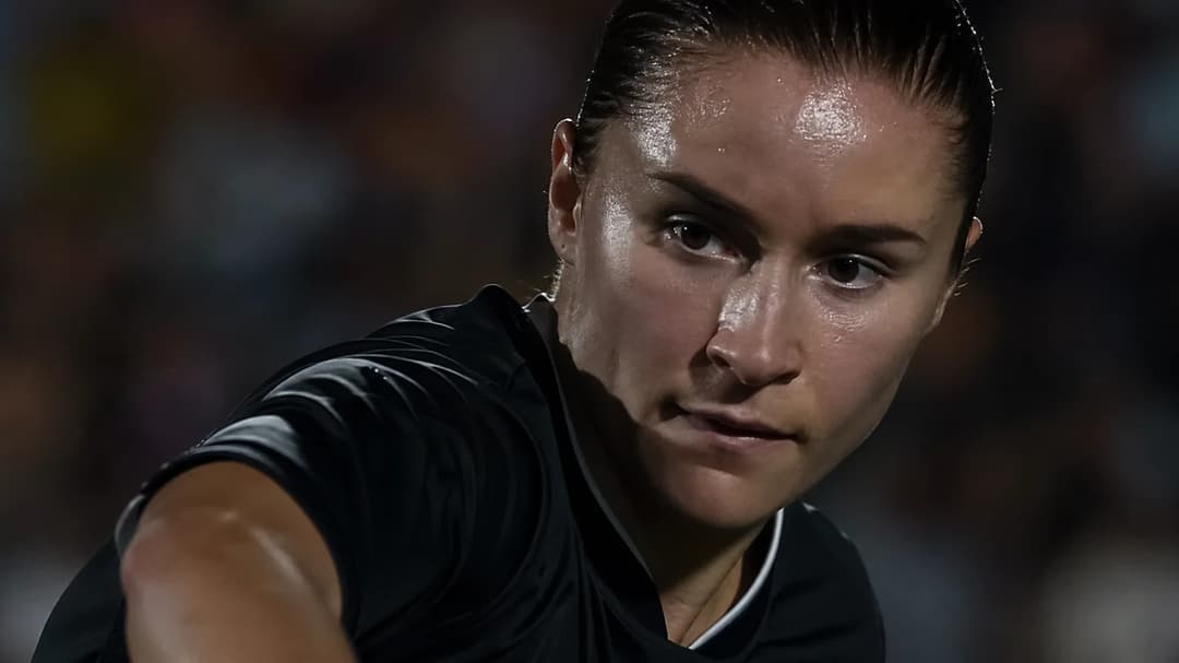 Close-up of a female football player concentrating before striking a ball.