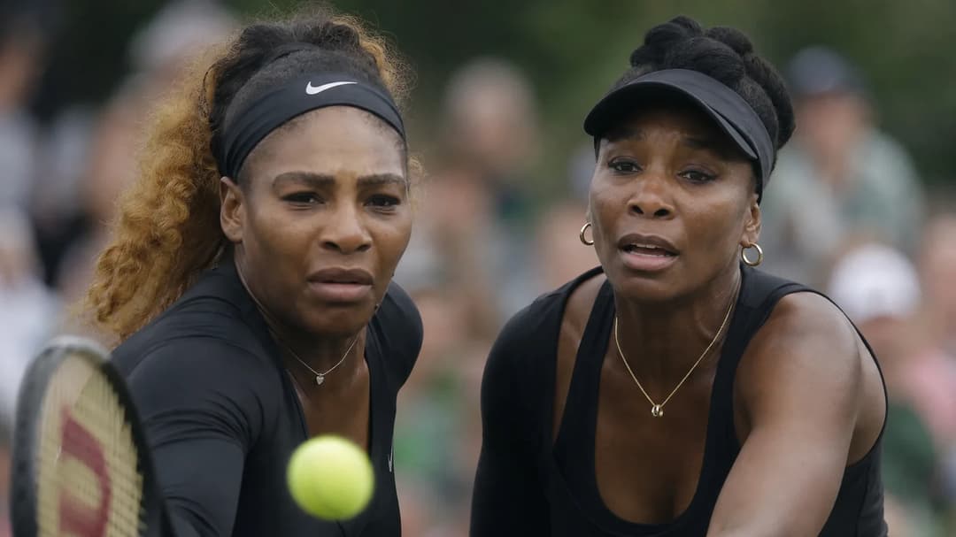 Close-up of Venus and Serena Williams displaying intense emotions during a tennis match.