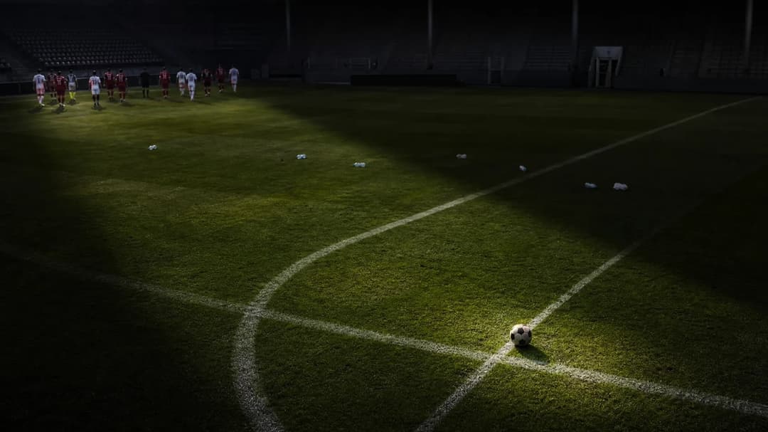 Bird's-eye view of an empty football pitch with a lone ball.