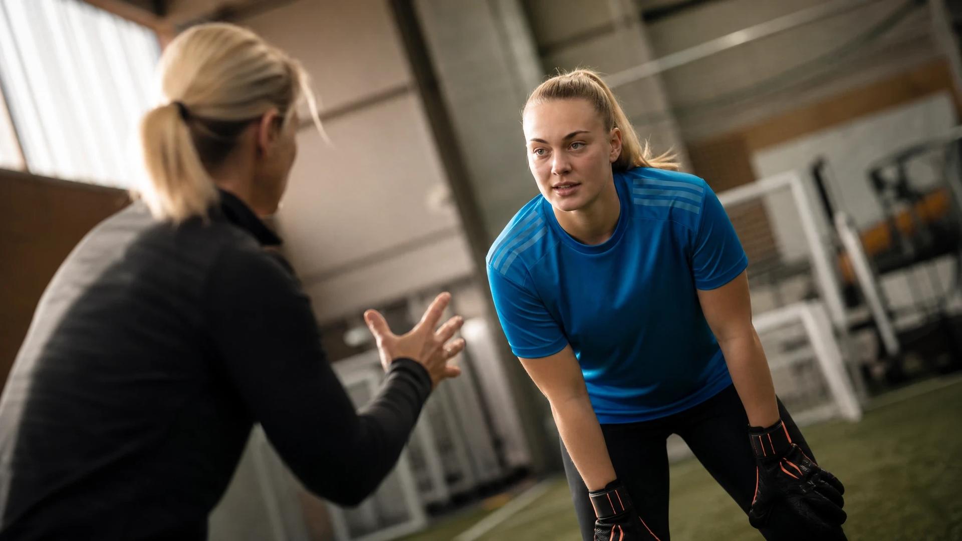 Katie Cox interacting with a teammate in a sports training facility.