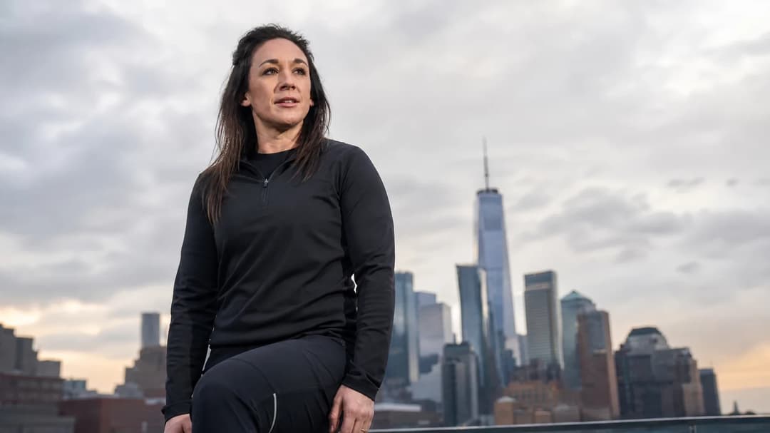 Nadine Keßler standing on a rooftop, overlooking a city skyline while dressed in sports attire.