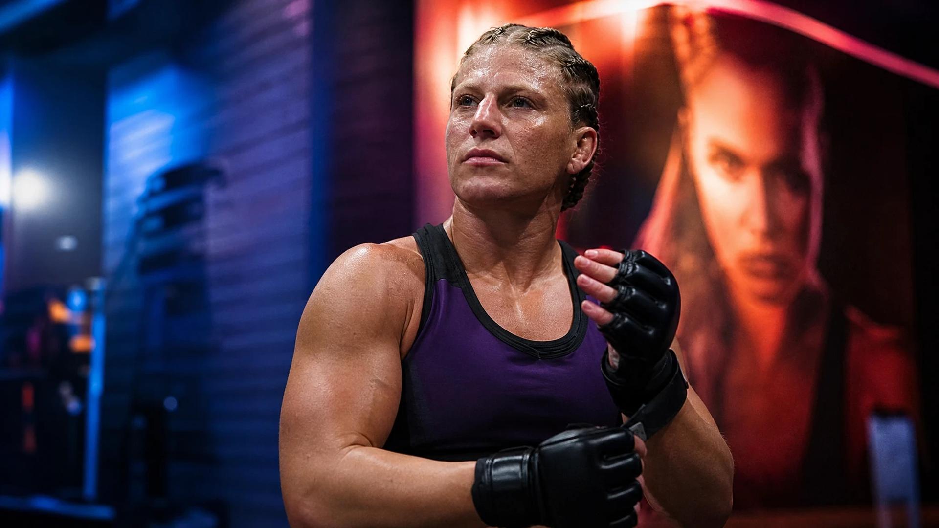 Kayla Harrison in a prep room, focused before her UFC debut, with neon lighting.