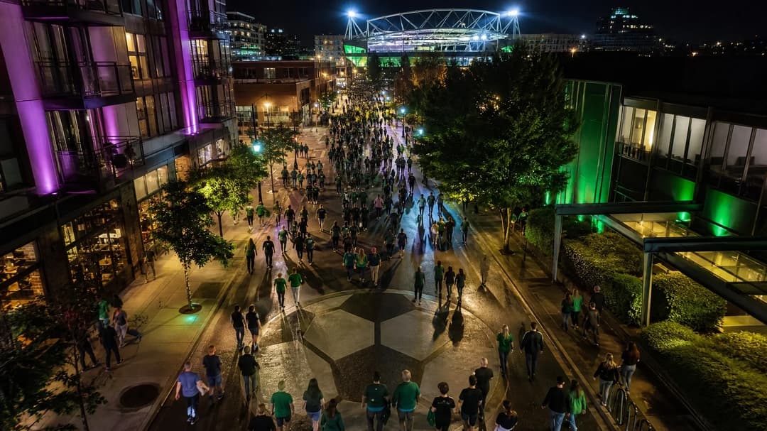 A bird's-eye view of fans heading to a women's football match among a vibrant urban landscape lit by neon lights.