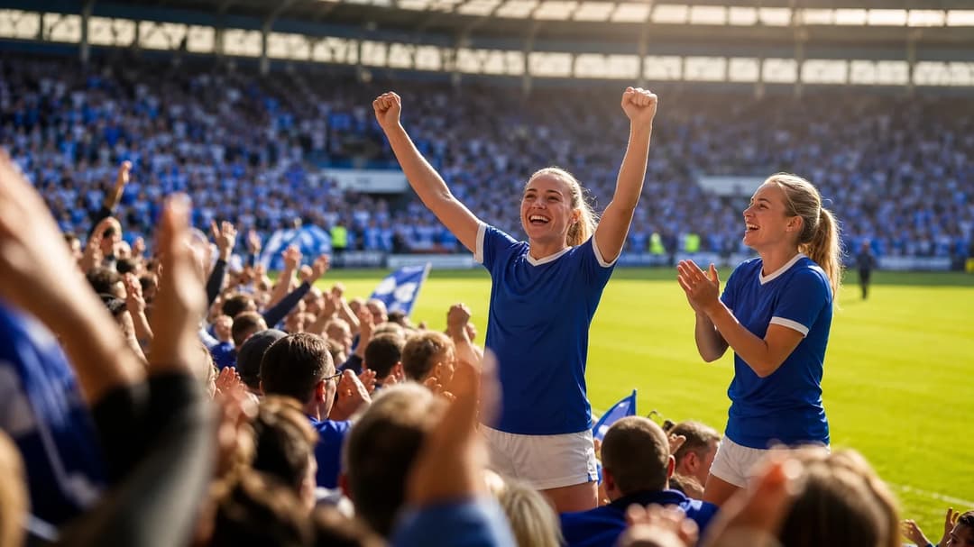 Two Birmingham City Women football players celebrating in a stadium filled with fans.