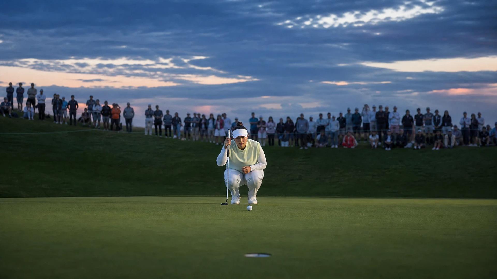 Miyu Yamashita on the golf course, preparing to take a putt at dusk.