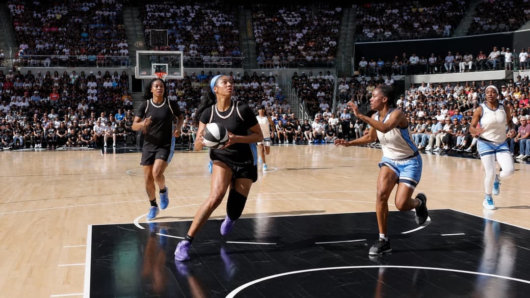 Angel Reese driving towards the basket during a WNBA game at Crypto.com Arena, surrounded by teammates and an engaged crowd.