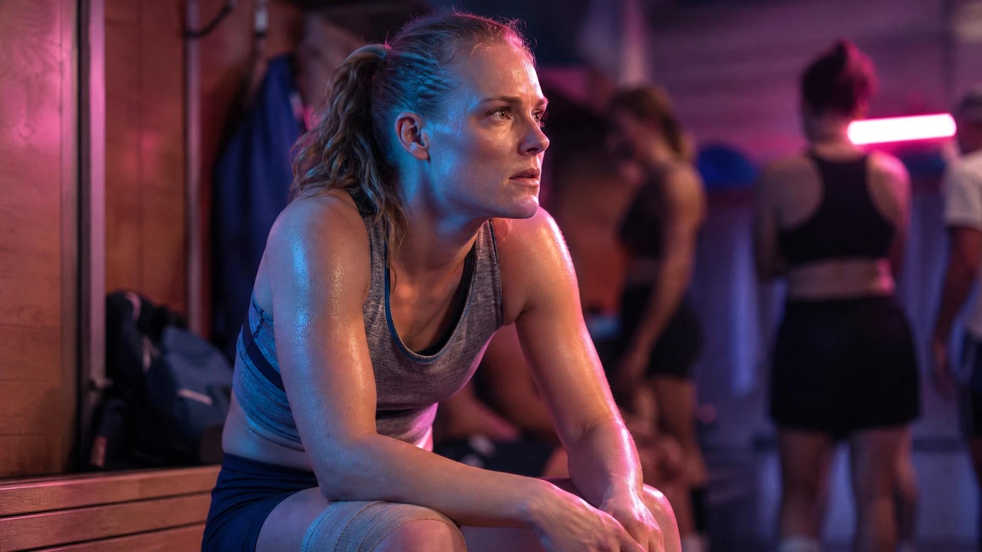 A close-up of Stine Ballisager in a locker room, showing her concern after an injury.