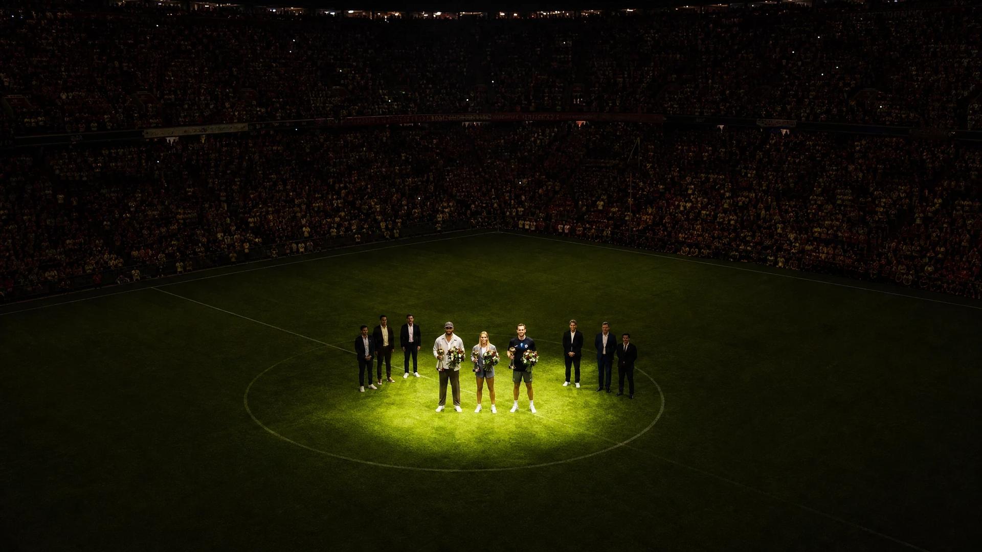Bird's-eye view of an awards ceremony at Allianz Arena, featuring Harry Kane, Vincent Kompany, and Giulia Gwinn.