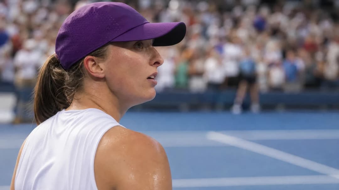Iga Swiatek celebrating her victory at the US Open, with a blurred background of spectators.