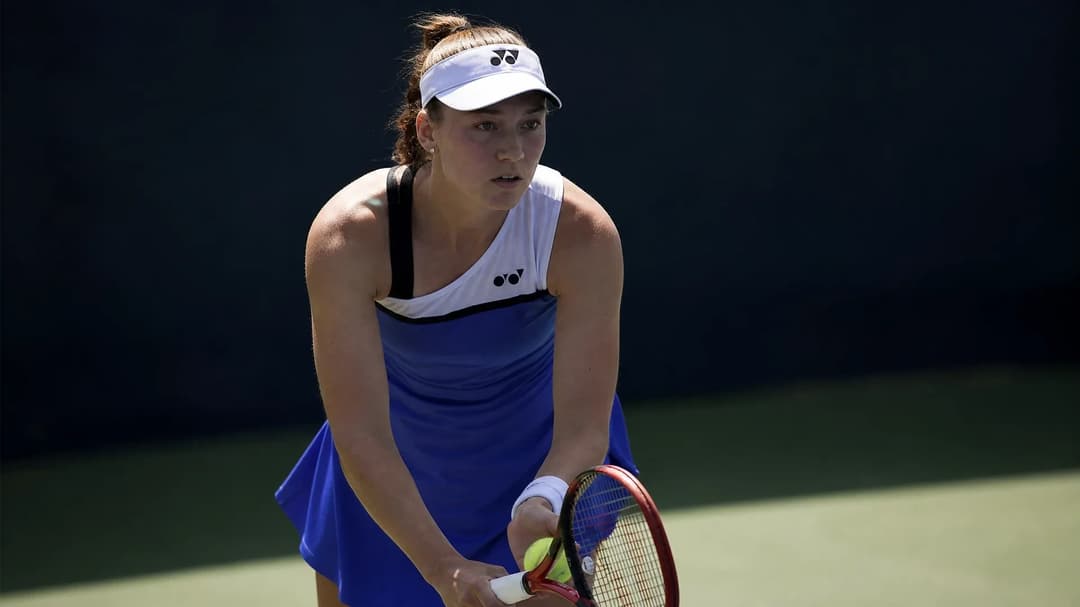 A young female tennis player, Thea Frodin, is poised on the court before serving, determined expression on her face.