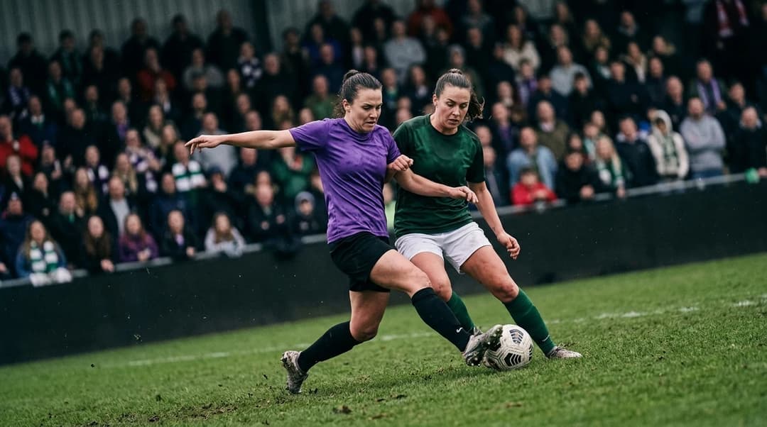 A tense moment between two female football players battling for possession during a match.