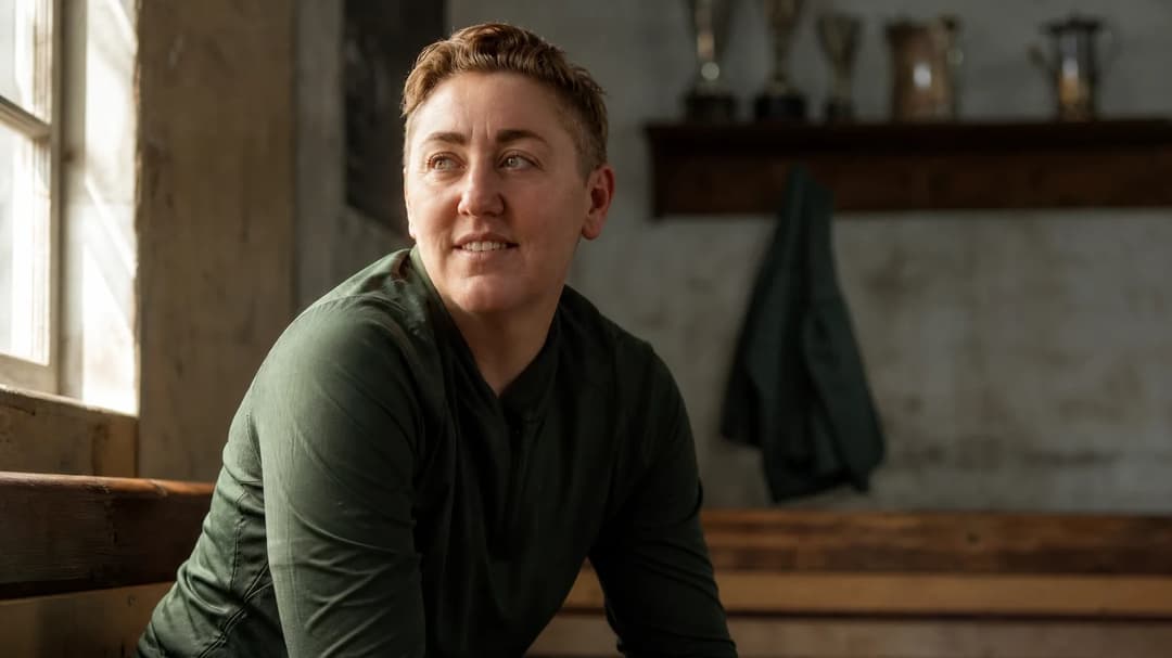 A close-up shot of goalkeeper Anna Moorhouse sitting in a locker room, illuminated by soft light from a window.