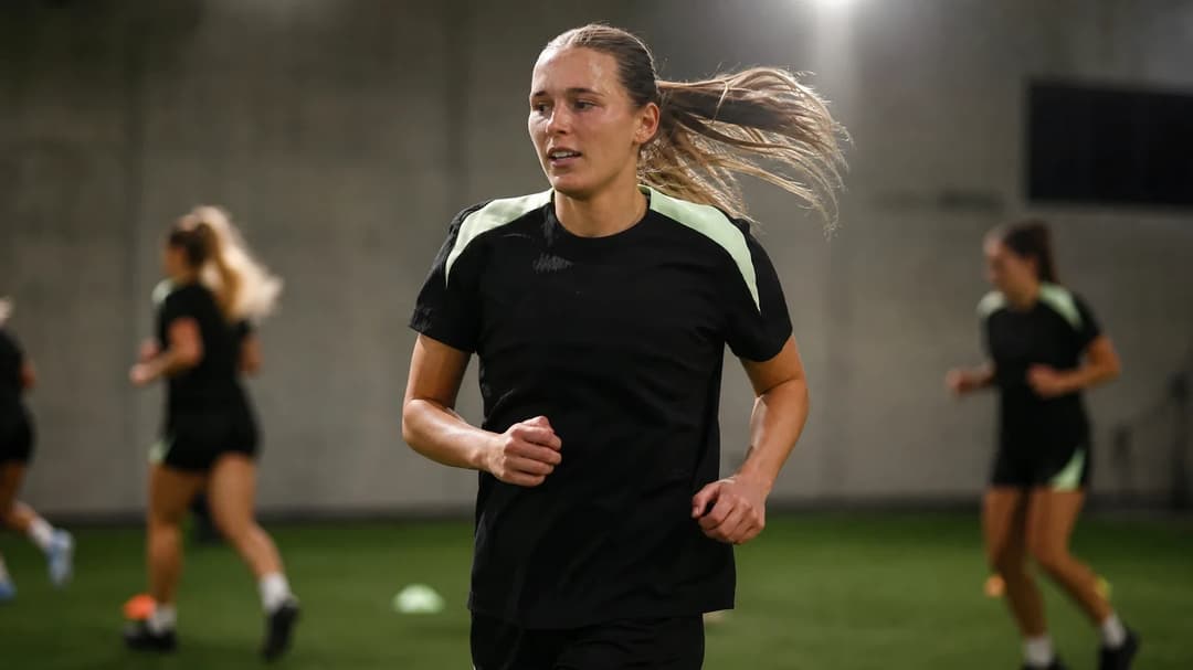 A female football player mid-training, focused and determined.