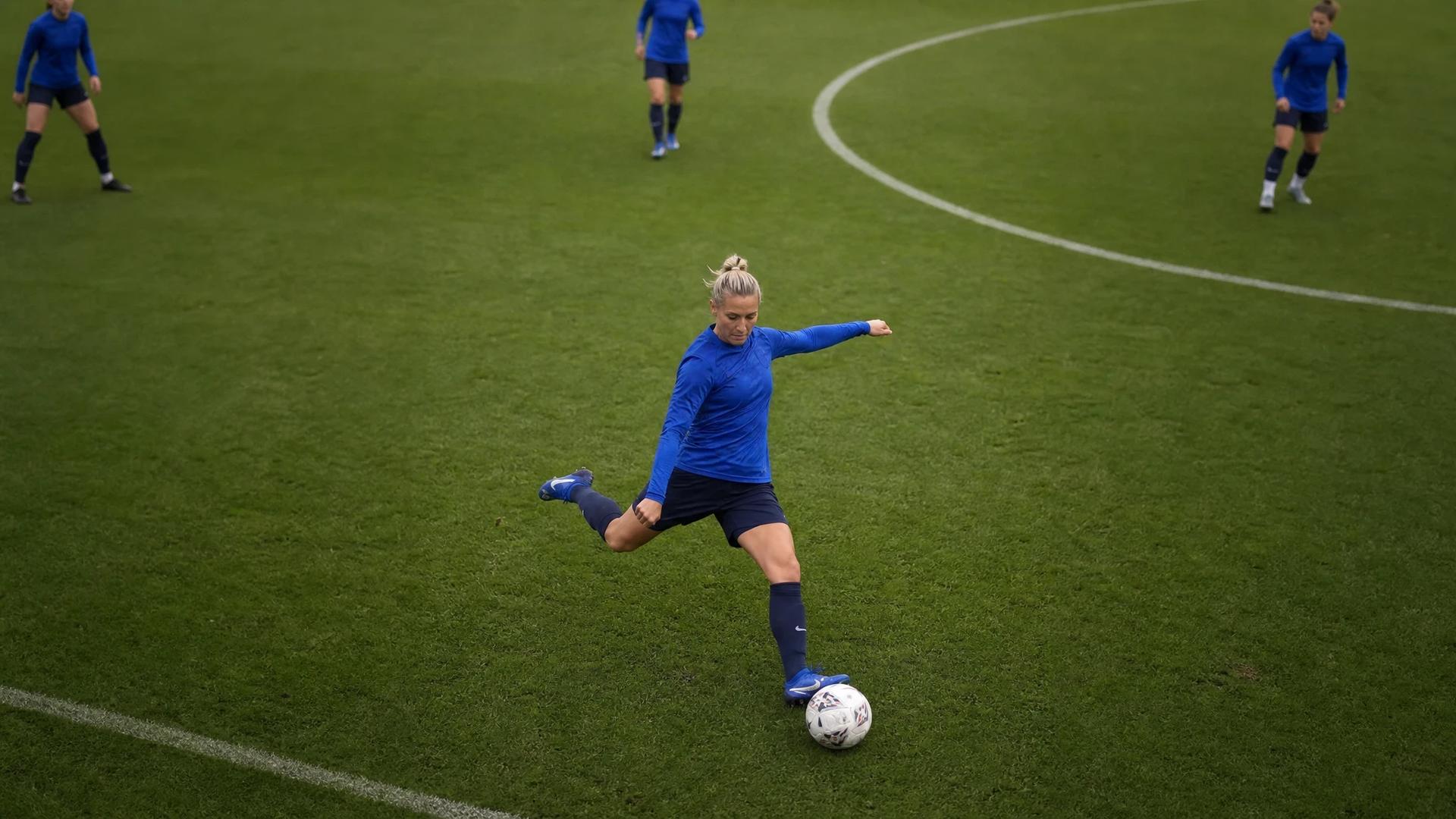 A top-down view of Emma Kullberg training on the football pitch in a blue kit.