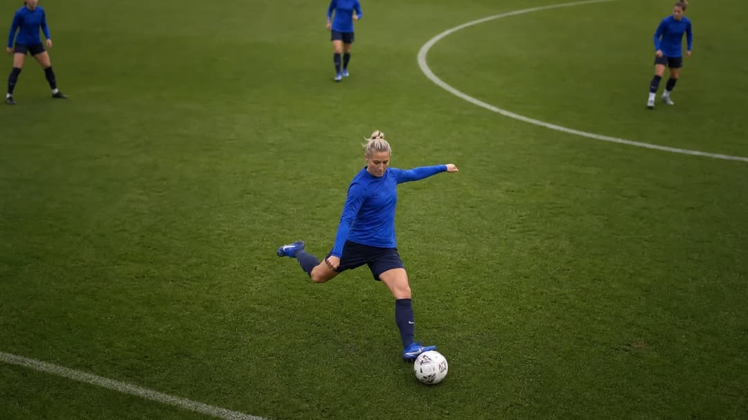 A top-down view of Emma Kullberg training on the football pitch in a blue kit.