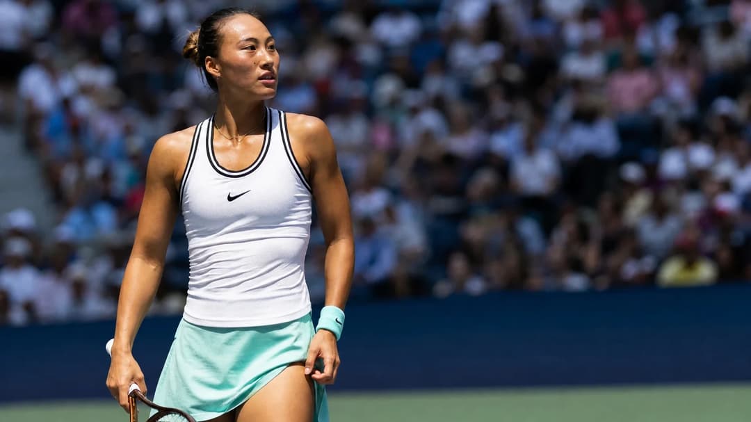 Zheng Qinwen poised for a serve at the US Open, silhouetted by the midday sun.