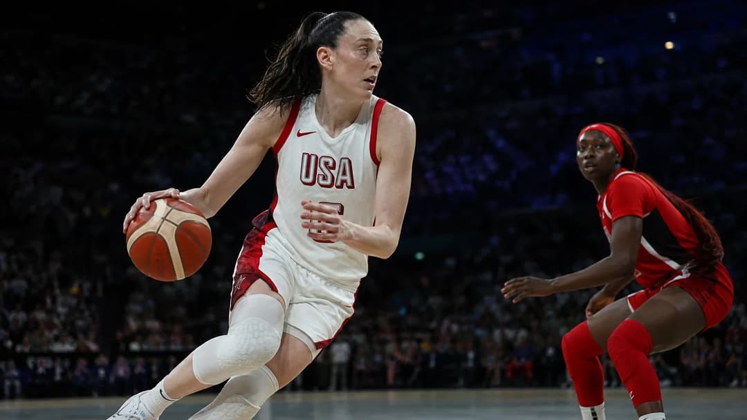 Breanna Stewart dribbling the ball during a basketball game in an arena.