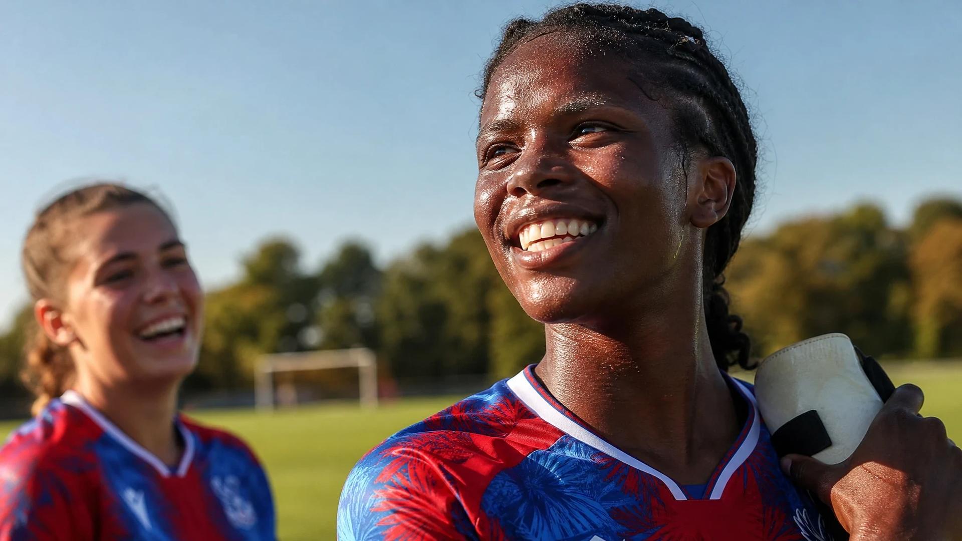 A female football player from Crystal Palace smiles as she reflects on a recent match.