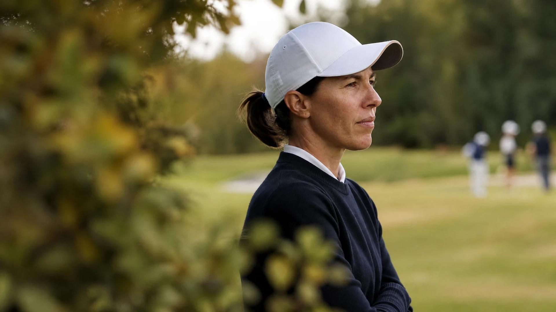 Close-up of Carlota Ciganda deeply focused and contemplative on the golf course.