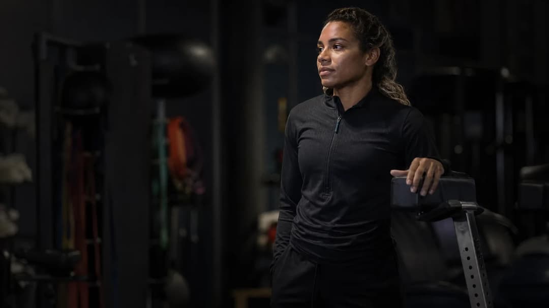 Catarina Macario, a female athlete, stands focused in a training facility, preparing for rehabilitation.