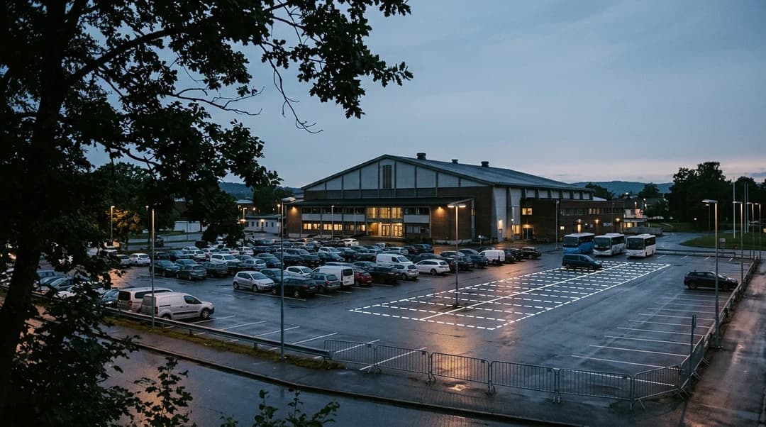 A wide shot of Bergslihallen in Larvik at dusk, highlighting planned parking area expansions.